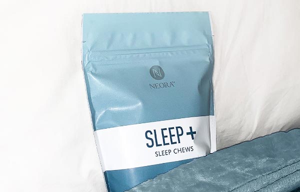 Sleep+ Wellness Chews next to a pillow.