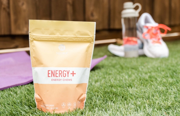 Lifestyle shot of Energy+ Wellness Chews sitting outside on grass.